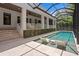 A screened-in pool with sun shelf, surrounded by lush greenery, creates a private outdoor oasis at 534 Ladrone Ave, Tampa, FL 33606