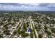 Wide aerial shot showing a home's location in a quiet, green neighborhood with distant cityscape views at 5611 Burlington N Ave, St Petersburg, FL 33710