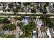 An aerial view shows a home with a private pool, nestled among lush trees in a residential neighborhood at 5611 Burlington N Ave, St Petersburg, FL 33710