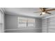 Bedroom featuring gray walls, white trim, built-in shelves, and a ceiling fan at 5611 Burlington N Ave, St Petersburg, FL 33710