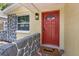 A close view of the red front door with brick accents and a 'home' doormat at 5611 Burlington N Ave, St Petersburg, FL 33710