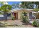 Charming single-story home featuring a red door, stone accents, and well-maintained front yard at 5611 Burlington N Ave, St Petersburg, FL 33710