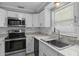 Modern kitchen featuring stainless steel appliances, white cabinets, and marble countertops at 5611 Burlington N Ave, St Petersburg, FL 33710