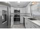 Contemporary kitchen featuring stainless steel appliances, white cabinets, and marble countertops at 5611 Burlington N Ave, St Petersburg, FL 33710