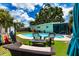 Relaxing backyard featuring a pool, outdoor furniture, and mature trees for shade at 6411 S Clark Ave, Tampa, FL 33616