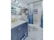Fresh bathroom featuring a vanity, bathtub with shower, and stylish blue and white flooring at 6411 S Clark Ave, Tampa, FL 33616