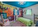 Bright bedroom features custom floral art wall, natural light, and is accented by a blue ceiling at 6411 S Clark Ave, Tampa, FL 33616