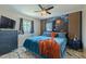 Comfortable bedroom features ceiling fan, modern blue decor, and a blue floral wall with wood detailing at 6411 S Clark Ave, Tampa, FL 33616