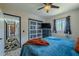 Comfortable bedroom features ceiling fan, modern blue decor, and natural lighting, and easy access to storage at 6411 S Clark Ave, Tampa, FL 33616