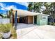 View of carport with brown accent wall, light green exterior, and side entrance at 6411 S Clark Ave, Tampa, FL 33616