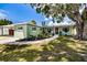 Well-manicured lawn and landscaping accentuates this home's exterior with driveway and mature trees at 6411 S Clark Ave, Tampa, FL 33616