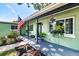 Inviting front porch with patterned concrete, an American flag, and decorative hanging plants at 6411 S Clark Ave, Tampa, FL 33616