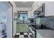 Stylish kitchen featuring modern appliances, sleek countertops, and a black and white tiled floor at 6411 S Clark Ave, Tampa, FL 33616