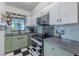 Modern kitchen with stainless steel appliances, stylish backsplash, and checkered floors at 6411 S Clark Ave, Tampa, FL 33616