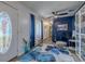 Inviting living room featuring a floral rug, blue accent wall, and decorative front door at 6411 S Clark Ave, Tampa, FL 33616