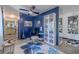 Stylishly decorated living room featuring a floral rug, blue accent wall and black and white tile floor at 6411 S Clark Ave, Tampa, FL 33616