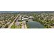 An aerial view shows a lakeside community surrounded by mature trees and nearby commercial development at 6453 5Th N Ave, St Petersburg, FL 33710
