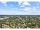 An aerial view shows a vast residential area with tree-lined streets stretching to the distant horizon under a bright, cloudy sky at 6453 5Th N Ave, St Petersburg, FL 33710
