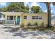 Charming yellow home featuring a welcoming turquoise front door and a cozy front porch at 6453 5Th N Ave, St Petersburg, FL 33710