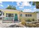 Charming yellow home featuring a welcoming turquoise front door and a cozy front porch at 6453 5Th N Ave, St Petersburg, FL 33710