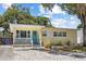 Charming yellow home featuring a welcoming turquoise front door and a cozy front porch at 6453 5Th N Ave, St Petersburg, FL 33710
