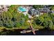 Aerial view of a dock, pools, clubhouse, and lush landscaping within the Wilderness Lake Preserve community at 7244 Wild Oak Ln, Land O Lakes, FL 34637