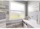 A bathroom featuring a white countertop, decorations, marbled tile, and a frosted window at 7244 Wild Oak Ln, Land O Lakes, FL 34637