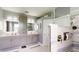 This renovated bathroom features dual sinks, storage, a toilet room, and a walk-in shower with marbled tile at 7244 Wild Oak Ln, Land O Lakes, FL 34637