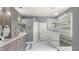 This renovated bathroom features dual sinks, storage, and a luxurious walk-in shower with marbled tile at 7244 Wild Oak Ln, Land O Lakes, FL 34637