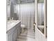 Bathroom featuring gray vanity with granite countertop and shower with patterned shower curtain at 7244 Wild Oak Ln, Land O Lakes, FL 34637