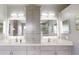 This renovated bathroom features dual sinks, vanity lights, storage, and sleek gray cabinets at 7244 Wild Oak Ln, Land O Lakes, FL 34637