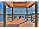 View of a dock extending onto a serene lake at Wilderness Lake Preserve, complete with an Adirondack chair at 7244 Wild Oak Ln, Land O Lakes, FL 34637