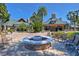 Community clubhouse exterior with a cozy stone fire pit and ample seating under sunny skies at 7244 Wild Oak Ln, Land O Lakes, FL 34637