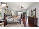 This spacious main bedroom features hardwood floors, a ceiling fan, a dresser, and a walk-out to the lanai at 7244 Wild Oak Ln, Land O Lakes, FL 34637