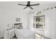 Bright bedroom features neutral decor, large window with natural light, and a ceiling fan at 7630 Sailwinds Pass, Port Richey, FL 34668
