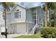 Charming two-story townhouse with a one-car garage, front steps and porch, and attractive tropical landscaping at 7630 Sailwinds Pass, Port Richey, FL 34668