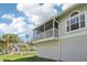 Charming home exterior showcasing a screened-in porch and well-maintained landscaping at 7630 Sailwinds Pass, Port Richey, FL 34668