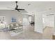 Bright, open-concept living room with neutral tones, ceiling fan, and abundant natural light at 7630 Sailwinds Pass, Port Richey, FL 34668
