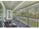 Relaxing screened porch with tile flooring and views of lush greenery, ideal for enjoying the outdoors at 7630 Sailwinds Pass, Port Richey, FL 34668