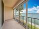 Enclosed balcony overlooking the blue waters of a bay, framed by palm trees and clear sky at 7665 Sun Island Dr # 206, South Pasadena, FL 33707