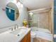 Well-lit bathroom featuring a shower-tub combo with glass doors and vanity with a stylish faucet at 7665 Sun Island Dr # 206, South Pasadena, FL 33707