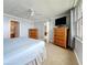 Bedroom features two dressers, neutral walls and carpet, ceiling fan and a view of a bathroom doorway at 7665 Sun Island Dr # 206, South Pasadena, FL 33707