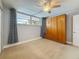 Neutral bedroom with a Murphy bed, light carpet, ceiling fan and a view of the outside at 7665 Sun Island Dr # 206, South Pasadena, FL 33707