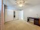 Sunlit bedroom with neutral carpet, light walls, mirrored closet, and a ceiling fan at 7665 Sun Island Dr # 206, South Pasadena, FL 33707