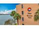 Exterior of The Essex building with palm trees and partial water view at 7665 Sun Island Dr # 206, South Pasadena, FL 33707