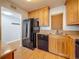 A bright kitchen displays a black refrigerator, stainless steel sink, and lots of wood cabinetry at 7665 Sun Island Dr # 206, South Pasadena, FL 33707