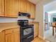Charming kitchen featuring black appliances, wood cabinetry, and granite countertops at 7665 Sun Island Dr # 206, South Pasadena, FL 33707