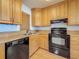 Galley kitchen showcases stainless steel sink, black appliances, granite countertops, and wood cabinets at 7665 Sun Island Dr # 206, South Pasadena, FL 33707