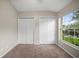 Bedroom featuring neutral walls, carpet flooring, two closets, and a large window with a view at 826 Addison Ne Dr, St Petersburg, FL 33716