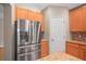 Stainless steel refrigerator in kitchen with wood cabinets and granite countertops at 826 Addison Ne Dr, St Petersburg, FL 33716